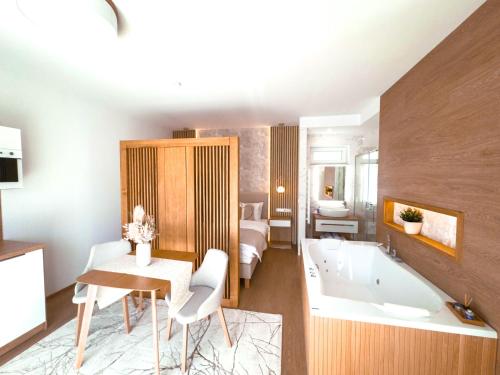 a large bathroom with a tub and a bedroom at M26 Prémium apartmanok in Tihany