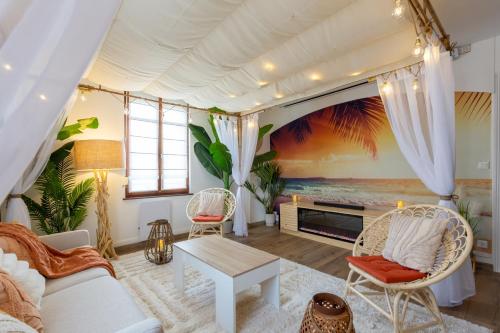 una sala de estar con un sofá y una mesa en CathyVoyages - Ciel étoilé - Bord de Mer - Parking gratuit - Vidéoprojecteur - Lit rond - La Paillote Strasbourgeoise, en Estrasburgo