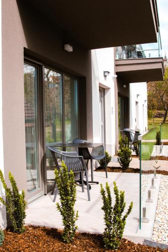 a patio with a table and chairs in a building at M26 Prémium apartmanok in Tihany