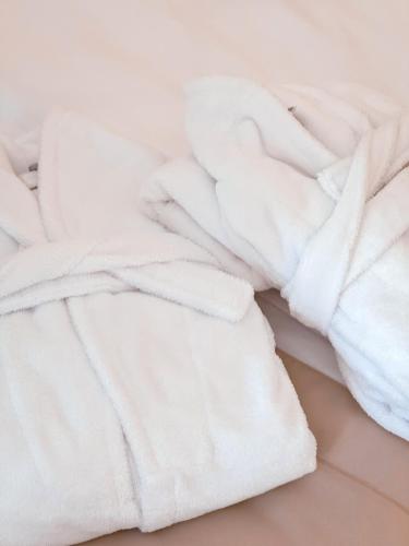 a pile of white towels on a bed at M26 Prémium apartmanok in Tihany