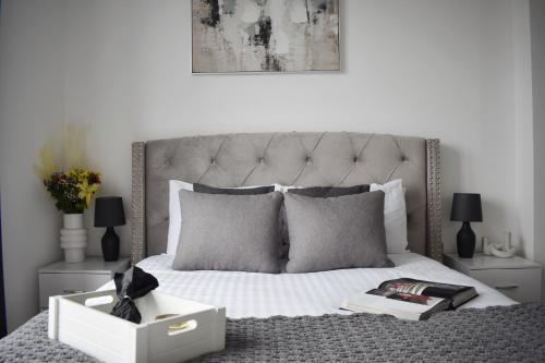 a bedroom with a white bed with a large headboard at Sleek 2 bed with balcony in Brentwood in Brentwood