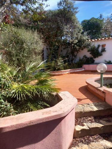 a garden with a patio with plants and a building at ZIRICHELTULA Villa PANORAMICA con ARIA CONDIZIONATA in Lu Pultiddolu