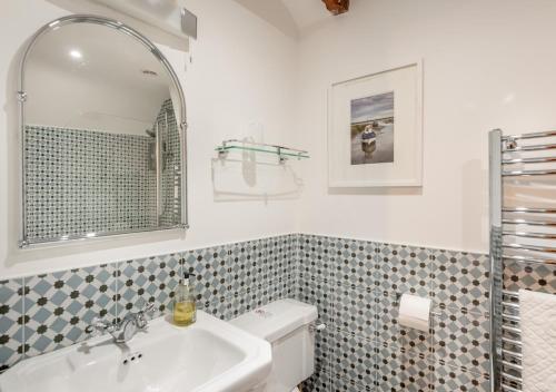 y baño con lavabo y espejo. en White Rose Cottage, en Bodham