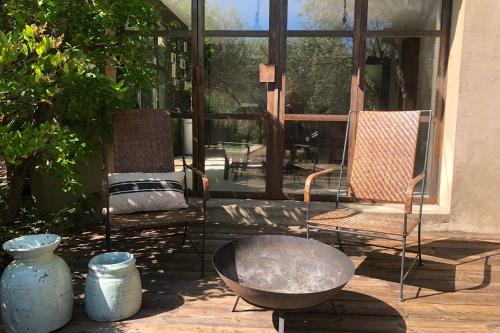 a patio with two chairs and a large window at La Matina Family Haven with Olive Garden Oasis in Lauris