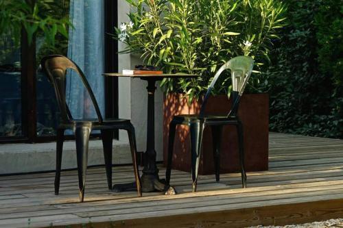 two chairs and a table in front of a plant at La Matina Family Haven with Olive Garden Oasis in Lauris