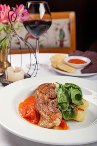 a plate of food on a table with a glass of wine at Hotel Victoria in Cuenca