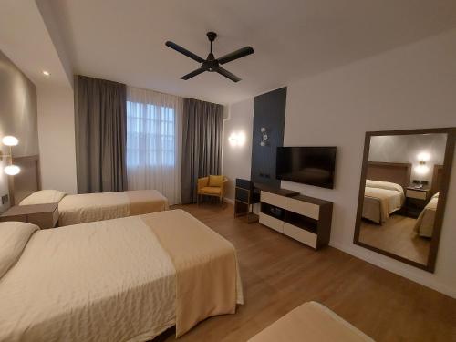 a hotel room with two beds and a ceiling fan at Hotel Internacional in Buenos Aires