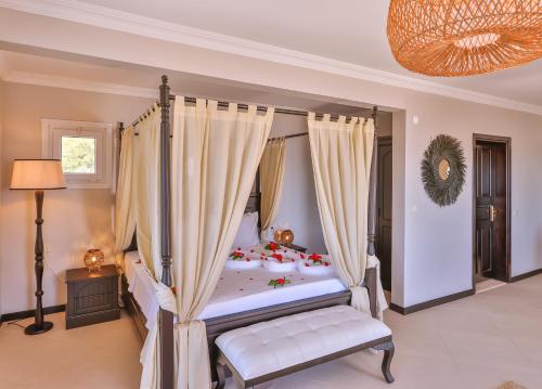 a bedroom with a canopy bed and a chandelier at Hill House Adult Only in Kas