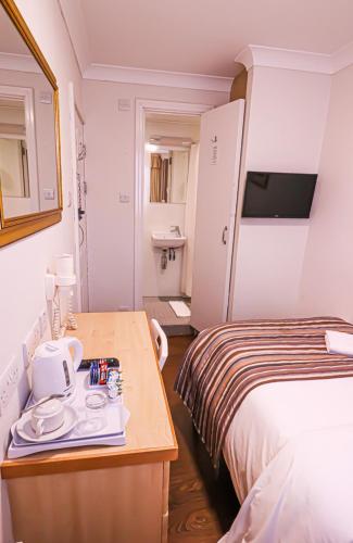 a hotel room with a bed and a desk and a bed at Fairway Hotel in London