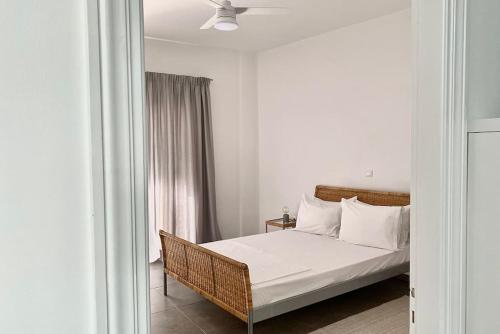 Schlafzimmer mit einem Bett mit weißer Bettwäsche und Kissen in der Unterkunft 3-bedroom central, spacious and bright apartment. in Iraklio