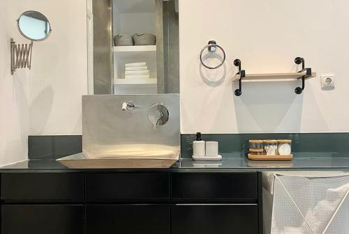 eine Küche mit einer Theke mit einem Waschbecken und Spiegeln in der Unterkunft 3-bedroom central, spacious and bright apartment. in Iraklio