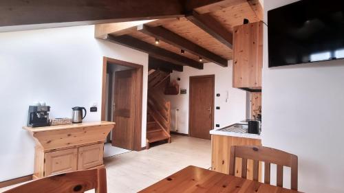 eine Küche mit Holzschränken und einem Holztisch in der Unterkunft B&B Casa Monella in Val di Sole in Monclassico