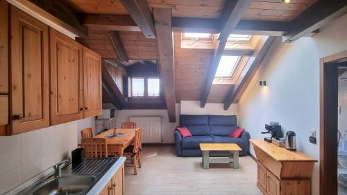ein Wohnzimmer mit einem blauen Sofa und einem Tisch in der Unterkunft B&B Casa Monella in Val di Sole in Monclassico