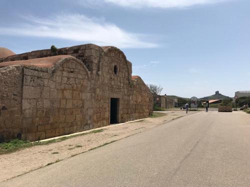 an old stone building with a door on the side of a road at Amazing BAY VIEW-BEACH BOUTIQUE Apartment VELAMEIGA in Funtana Meiga