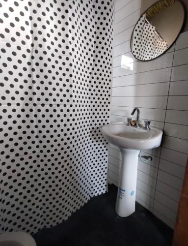 a white bathroom with a sink and a mirror at Cabañas Riviera in Huacalera