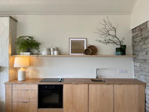 a kitchen with a wooden counter with a microwave at Salt Cliff Cottage in Doolin