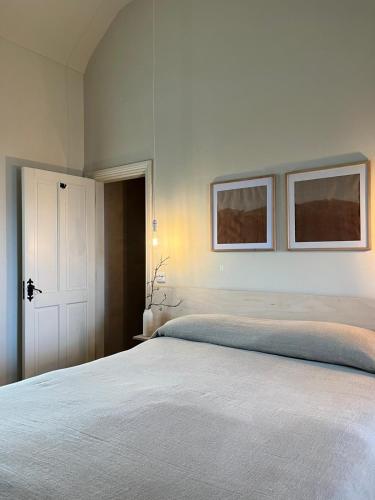 a bedroom with a bed with two pictures on the wall at Salt Cliff Cottage in Doolin