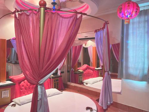 um quarto com cortinas cor-de-rosa e 2 camas em Xangai Motel by Drops em São Leopoldo