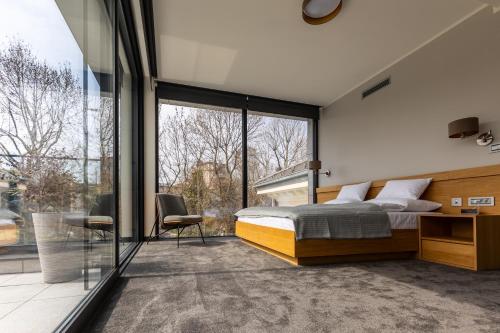 a bedroom with a bed and a large window at Basch House 1887 Rooms, Subotica in Subotica