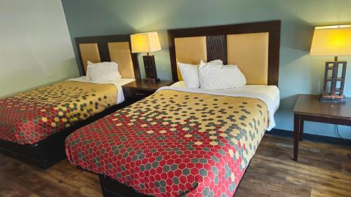 Habitación de hotel con 2 camas y 2 mesas en EconoLodge Lavonia en Lavonia