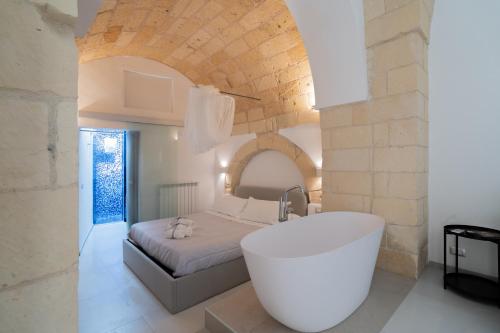 a bathroom with a bath tub and a bed at Corte dei Condò Luxury Rooms in Lecce