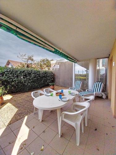 une table et des chaises sur une terrasse avec vue sur l'océan dans l'établissement V-Dune 01-Vieux Boucau Appartement 4 personnes proche de la plage, à Vieux-Boucau-les-Bains