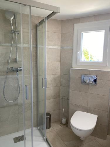 une salle de bain avec toilettes et douche en verre dans l'établissement Appartement Marina di Fiori by Intendance Excellency, à Porto-Vecchio