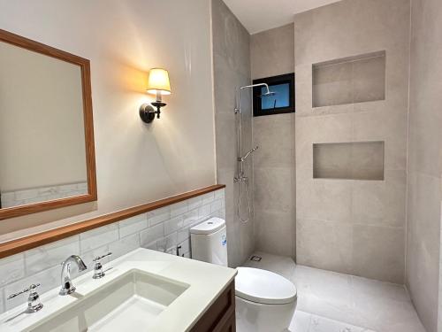 ein Badezimmer mit einem Waschbecken, einem WC und einem Spiegel in der Unterkunft House40 - MRT Ratchadaphisek in Bangkok