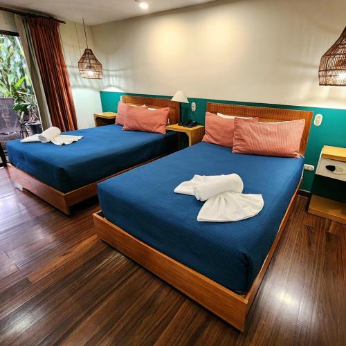 two beds in a room with blue sheets at Hotel Aranjuez in San José