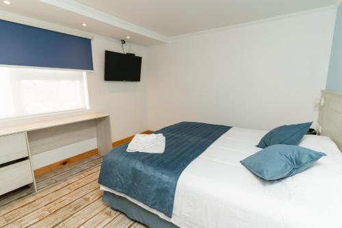 1 dormitorio con cama, ventana y TV en Hotel Mareblu Iquique, en Iquique