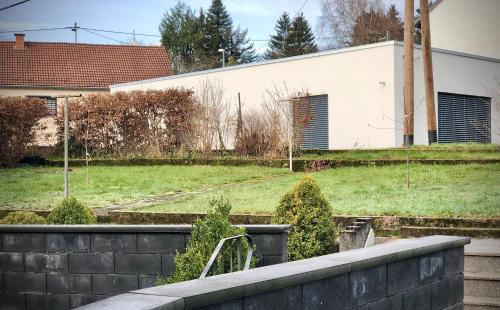 a house with a yard with a retaining wall at Schneiders Ferienwohnungen in Braunshausen