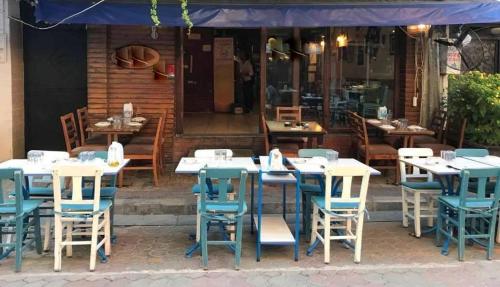 grupa stołów i krzeseł poza restauracją w obiekcie Alsancak Konak seaside 50 mt walk Double room w mieście Konak