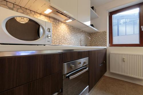 a kitchen with a microwave above a stove at The Queen Luxury apartments - Villa Giorgia in Dudelange