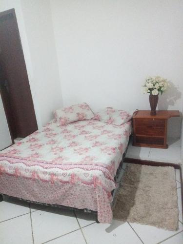 ein Schlafzimmer mit einem Bett und einer Vase aus Blumen in der Unterkunft Pousada verde mar in Cabo Frio