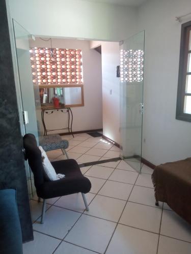 a living room with a chair and a glass door at Pousada verde mar in Cabo Frio