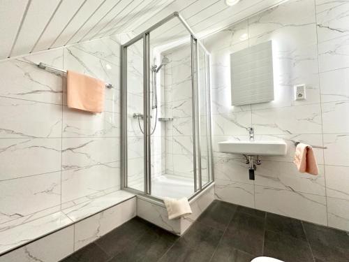 a white bathroom with a sink and a shower at Hotel Deutsches Haus mit WLAN und Parkplatz, HDZ und Kliniken in der Nähe, direkt an der A2 und A30 gelegen in Löhne