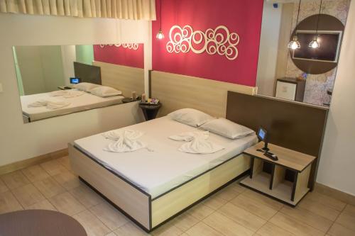 una camera con due letti e uno specchio di Luna's Motel a Sumaré