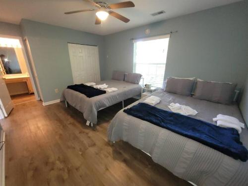 um quarto com 2 camas e uma ventoinha de tecto em Pawleys Island Retreat sleeps 8+ 3bed 2 bath em Pawleys Island