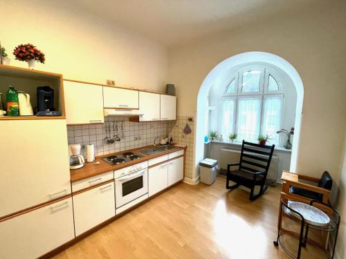 eine Küche mit einem Bogenfenster sowie einem Tisch und Stühlen in der Unterkunft Fewo TRINA in Bernkastel-Kues