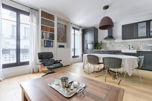 une cuisine et un salon avec une table et des chaises dans l'établissement Trocadero/TourEiffel : havre de paix 2 Chambres, à Paris