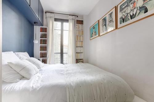 un lit blanc dans une chambre avec une fenêtre dans l'établissement Trocadero/TourEiffel : havre de paix 2 Chambres, à Paris