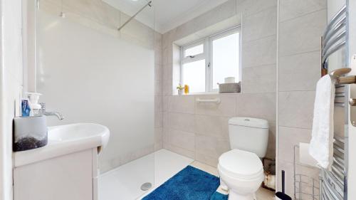 a white bathroom with a toilet and a sink at Stunning 3-Bed House in Basildon in Basildon