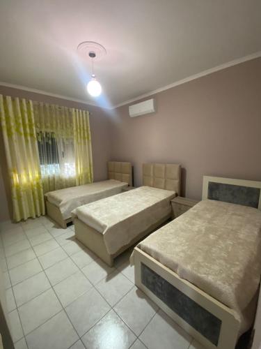 ベラトにあるVila Besimのベッド3台と照明付きの部屋
