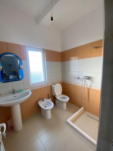 ベラトにあるVila Besimのバスルーム(洗面台、トイレ付)、窓が備わります。