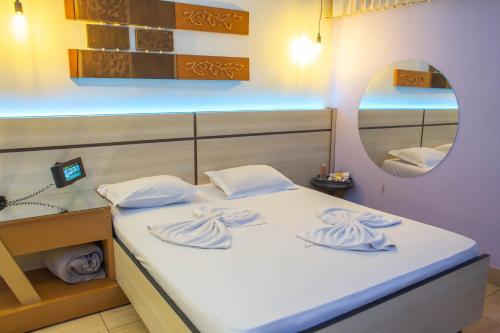 una camera con un grande letto e uno specchio di Luna's Motel a Sumaré
