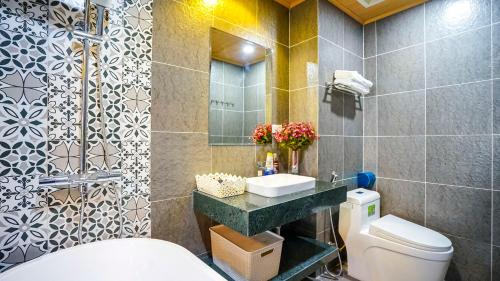 een badkamer met een toilet, een wastafel en een spiegel bij Hanoi Ben's Apartment and Hotel in Hanoi