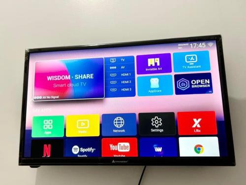 a television with different colored screens on a wall at Semi Studio Room at EKG House Rental in Manila