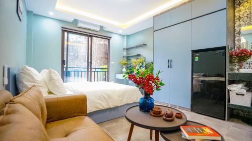 河內的住宿－Hanoi Ben's Apartment and Hotel，客房设有床、沙发和桌子。