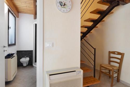 a bathroom with a staircase and a clock on the wall at Melograno Agriturismo La Ferla in Toirano