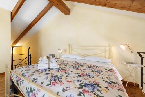 a bedroom with a bed with a floral bedspread at Melograno Agriturismo La Ferla in Toirano